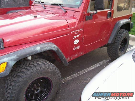 Red 1998 Jeep TJ Wrangler 4.0L Sport side view with tan soft top