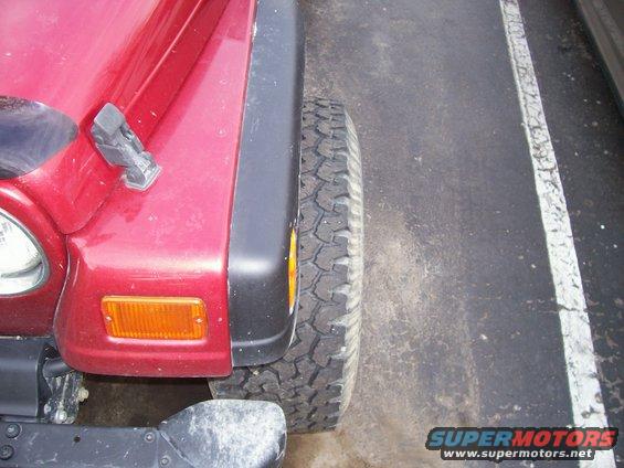 Red Jeep Wrangler front fender and tire, close-up side view