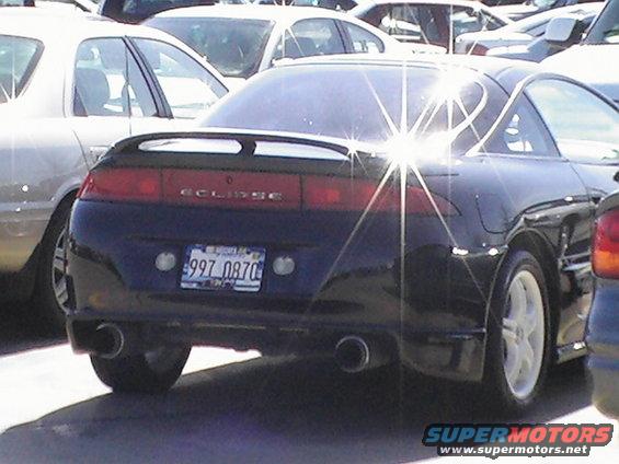 Black coupe with a rear spoiler and dual exhaust pipes. License plate reads 997 0870