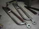 1978 Ford Bronco - Custom metal radius arms with rod ends are laid out on a concrete floor.