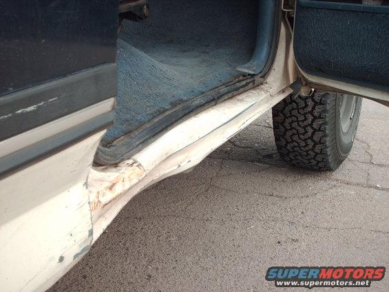 Damaged door sill and tire of a vehicle. Supermotors.net logo visible