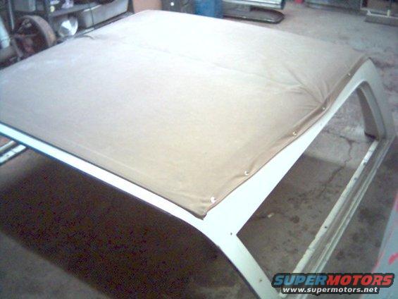 soft top frame with tan fabric stretched over it, inside a garage