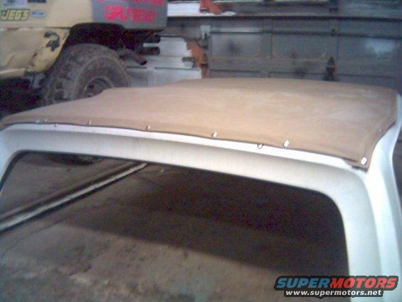 Tan soft top on a white vehicle, with another vehicle in the background that has 'JEGS' and 'SPLINTER' text on it