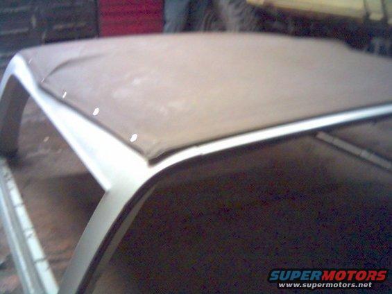 Soft top frame with tan fabric cover, showing attachment points