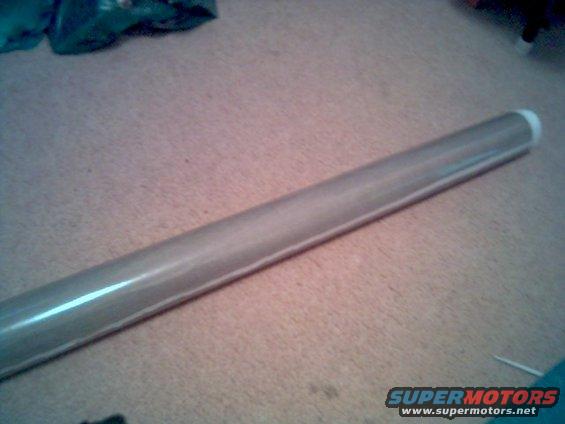Silver metal tube with white end cap on carpeted floor