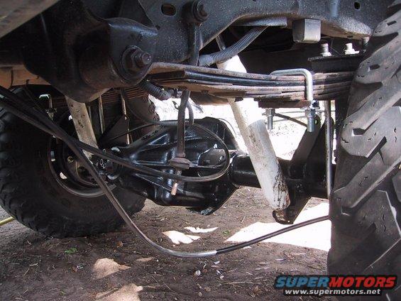 Close-up of a vehicle's rear axle, leaf springs, and shock absorber