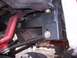 1990 Ford Bronco - Close-up view of the undercarriage of a vehicle, showing various mechanical components and suspension elements.