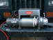 1994 Jeep YJ - A Warn winch is mounted to the front bumper of a vehicle, with orange turn signals visible on either side.