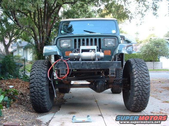 Green Jeep Wrangler with large tires and a winch mounted on the front bumper