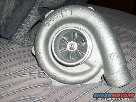 Silver Garrett turbocharger with "AIR-50" and "33" cast into its housing, resting on a striped fabric