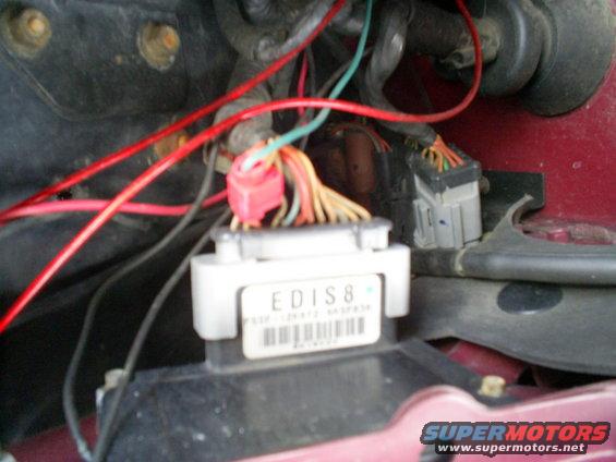Engine control module labeled EDIS8 with wiring harness connected, red and orange wires visible