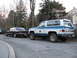 1992 Ford Crown Victoria - A dark sedan is seen from the rear, parked alongside a two-tone blue and white GMC SUV on a street.