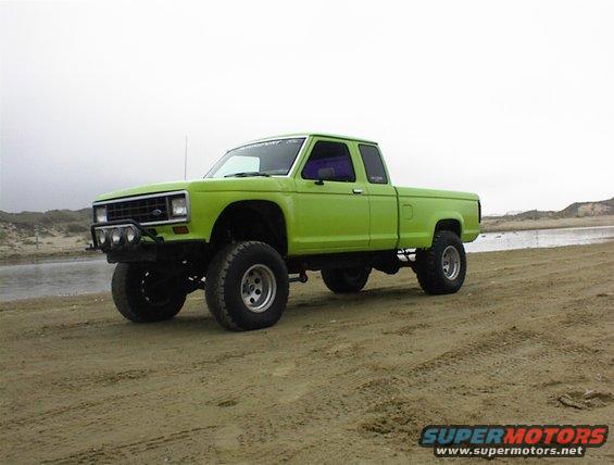 Lime green lifted pickup truck parked on a sandy beach