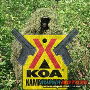 KOA Kampgrounds sign with crossed pistols and a person in a ghillie suit