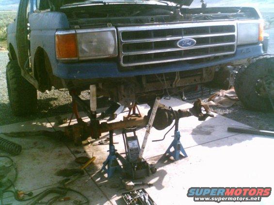 Ford truck front end up on jack stands with the axle removed. Hood is open