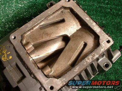 Close-up of a supercharger rotor housing with visible wear. Supermotors.net logo in the corner