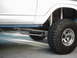 1978 Ford Bronco - Close-up of the side of a modified off-road vehicle, highlighting its suspension and large tires.