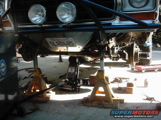 1978 Ford Bronco front end raised on jack stands with suspension components visible. California license plate 5LQ D485 is mounted below the bumper