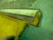 1979 Ford Bronco - Close-up of a worn interior door panel, showing yellow upholstery and exposed metal components.