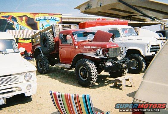Red Dodge Power Wagon with spare tire on side, parked outdoors