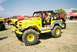 1989 Ford F-350 - A bright yellow off-road vehicle is parked outdoors with other vehicles in the background under a clear sky.