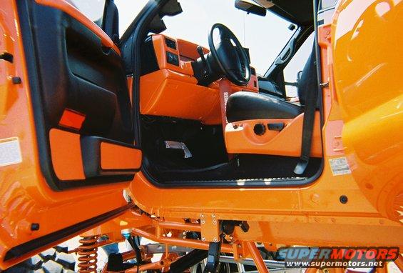 Interior view of a lifted truck with custom orange accents on the door panels and dashboard