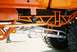 1989 Ford F-350 - Close-up view of the custom suspension and frame of an orange off-road truck.