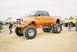 1989 Ford F-350 - This heavily modified truck features an orange paint scheme and massive off-road tires.