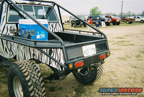 1989 Ford F-350 pickup truck with zebra print bed and roll cage, rear view. License plate HIC-778