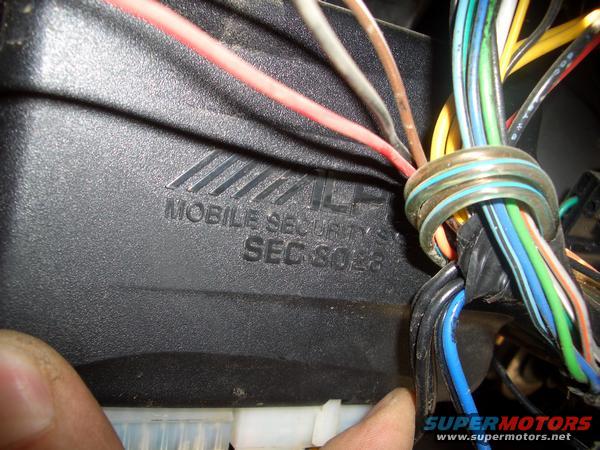 Car alarm module with "MOBILE SECURITY SEC 8028" text and wiring