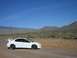 1996 Ford Probe - A white Dodge Neon SRT-4 is parked on a dirt road with a mountainous desert landscape under a clear blue sky.