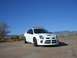 1996 Ford Probe - A white Dodge Neon SRT-4 is parked on a dirt road with a desert landscape in the background.