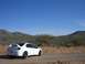 1996 Ford Probe - A white Dodge Neon SRT-4 is parked on a dirt road in a desert landscape under a clear blue sky.