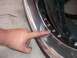 1996 Ford Probe - A finger points to the bolts on a shiny metal wheel rim.