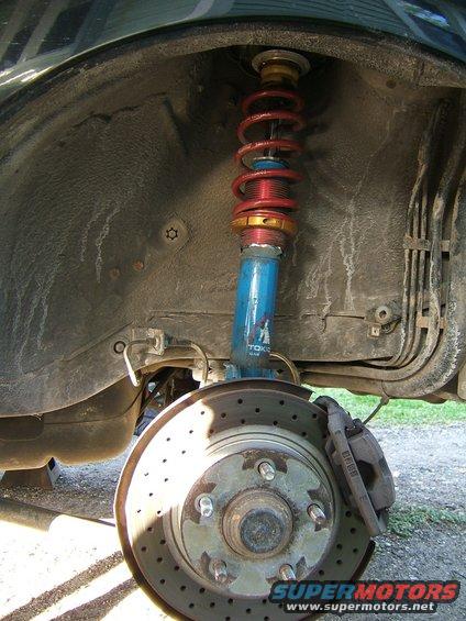 Front wheel suspension part with blue Tokico shock and red coilover spring