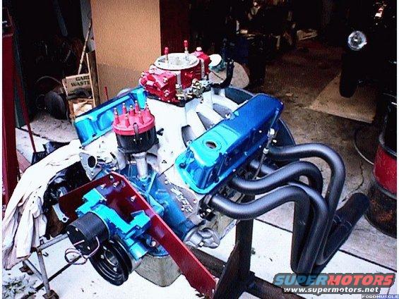 Blue and red engine on stand with black headers