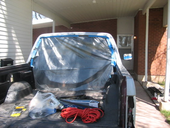 Pickup truck bed with plastic sheeting and painting supplies