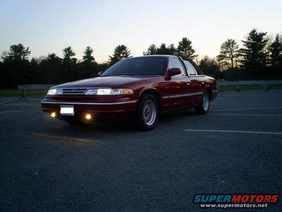 Maroon sedan parked in a lot at dusk. It's a 1995 Ford Crown Victoria