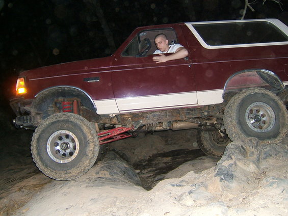 Maroon and white 1993 Ford Bronco navigating rocky terrain