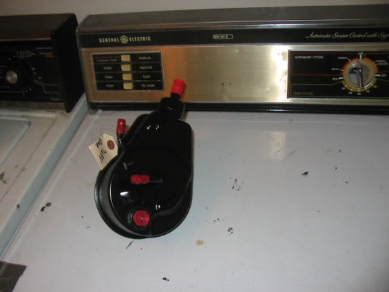 black power steering pump with red caps on fittings, tag attached