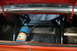 1981 Ford Mustang - The trunk of a red car reveals a NOS tank, battery, and roll cage, suggesting performance modifications.