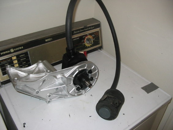 Silver power steering pump bracket with black hose and cap