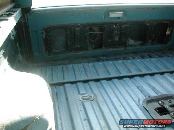 Interior of a teal truck bed with ribbed flooring and a removed tailgate panel