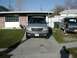 1981 Ford Bronco - Two SUVs are parked in a driveway in front of a garage and house.