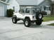 1995 Jeep Wrangler - A white 1995 Jeep Wrangler is parked on a concrete driveway in front of a house.
