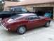 1969 Ford Mustang - A classic Mustang is parked outside a garage, with other vehicles visible.