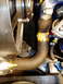 1966 Ford Fairlane - A close-up view of engine components, including hoses and a fan shroud, with some visible text on a yellow label.