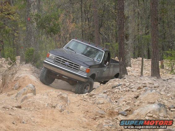 1990 Ford Bronco navigating rocky terrain off-road