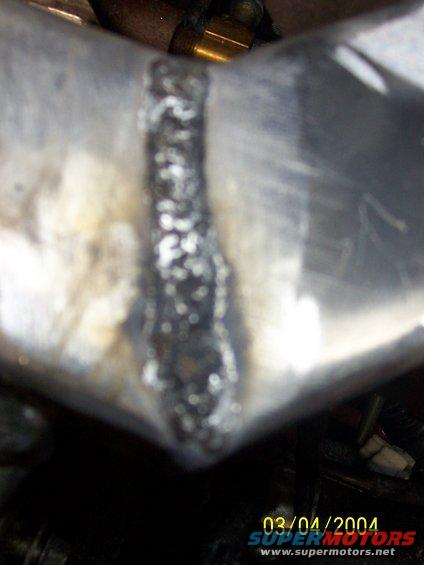 Close-up of a welded metal pipe with a date stamp of 03/04/2004
