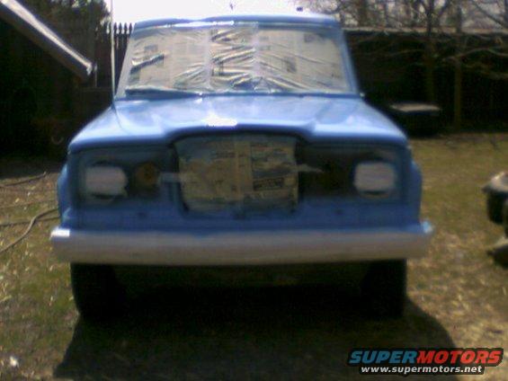 Blue SUV front view, windows taped for painting